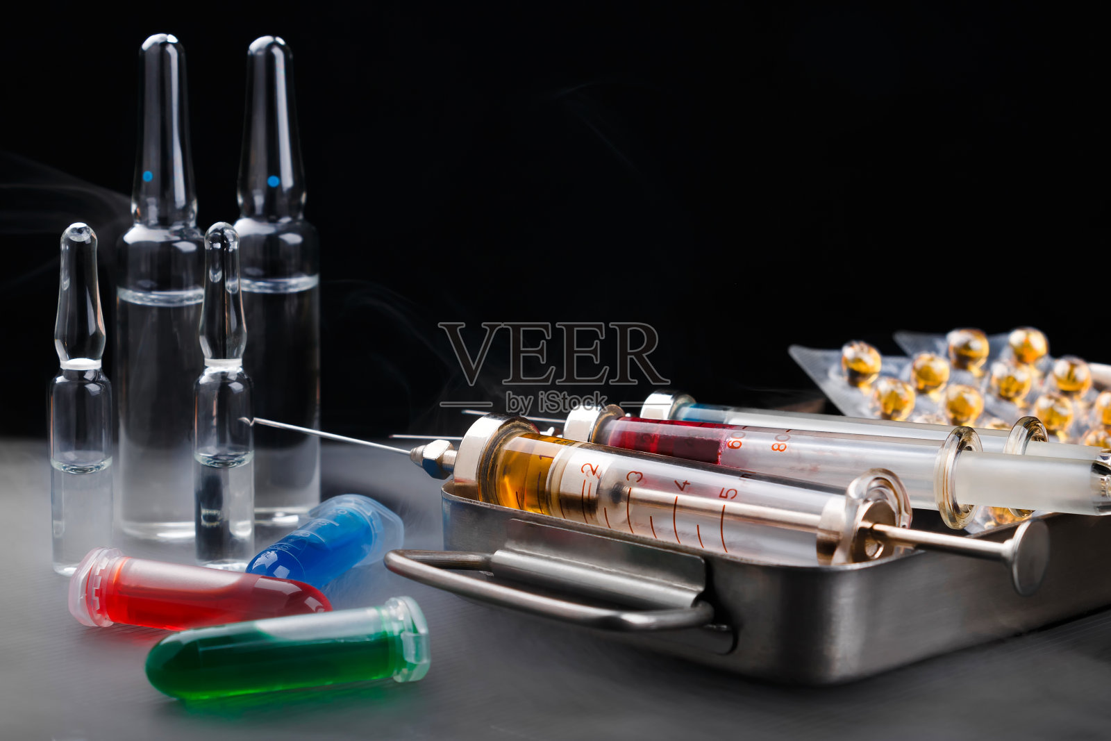 带药物的注射器放在灭菌盒上，安瓿和小瓶表面雾水照片摄影图片