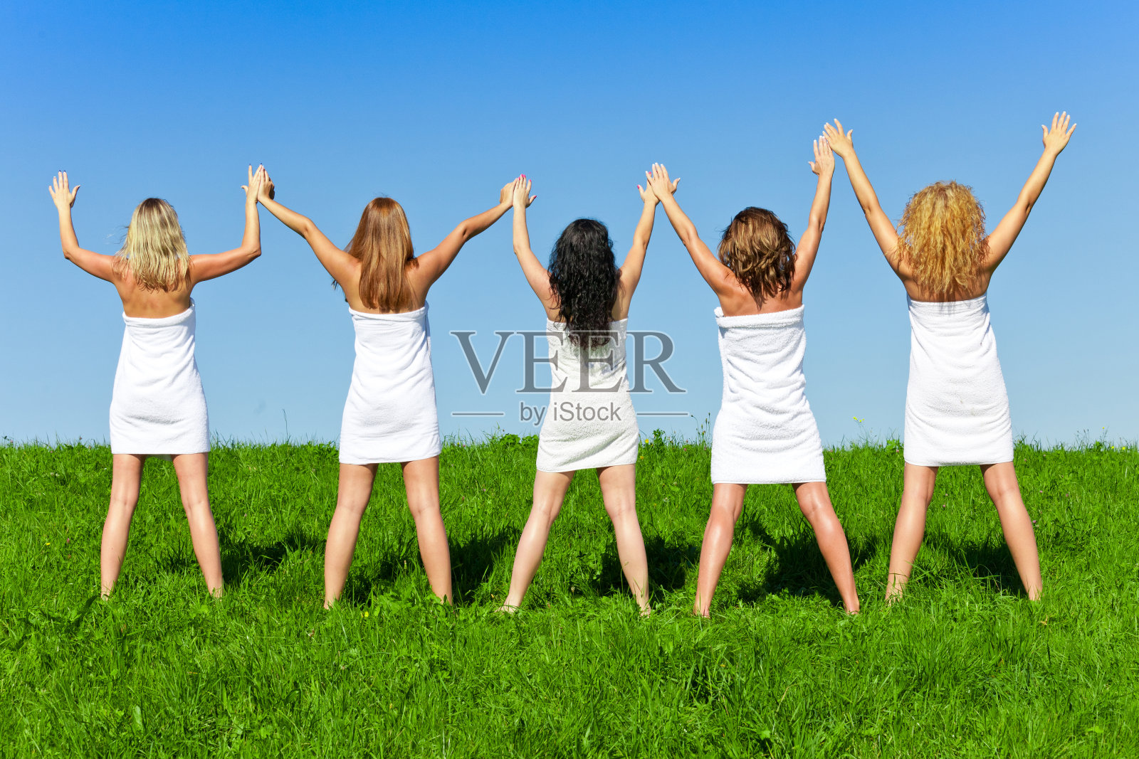 一群裹着毛巾的妇女在夏日的草地上照片摄影图片