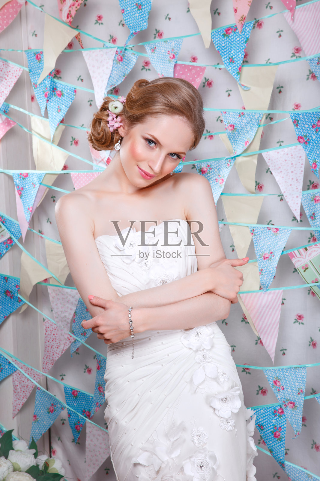 有婚礼发型和化妆的美女。新娘时尚。珠宝和美丽。穿白色衣服的女人，完美的皮肤，金发。发型时髦的女孩。婚礼装饰。新娘用鲜花照片摄影图片