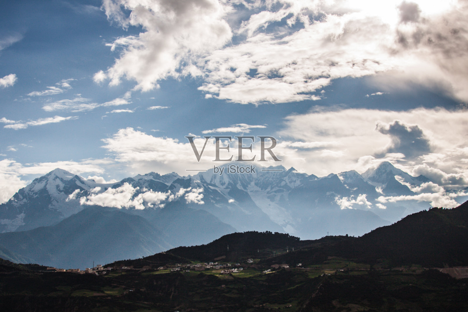中国云南梅里雪山景观，小村庄以雪山为背景的清晨。照片摄影图片