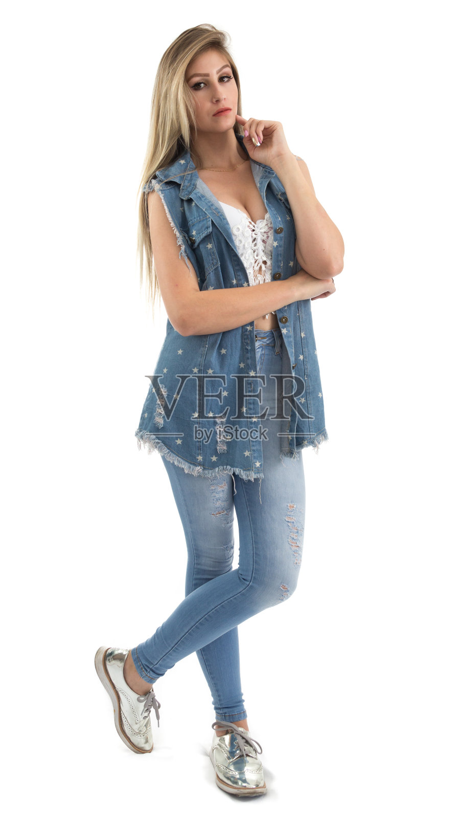 一个美丽女人的肖像。全身的照片。金发的人穿着牛仔裤背心。白色背景。n照片摄影图片