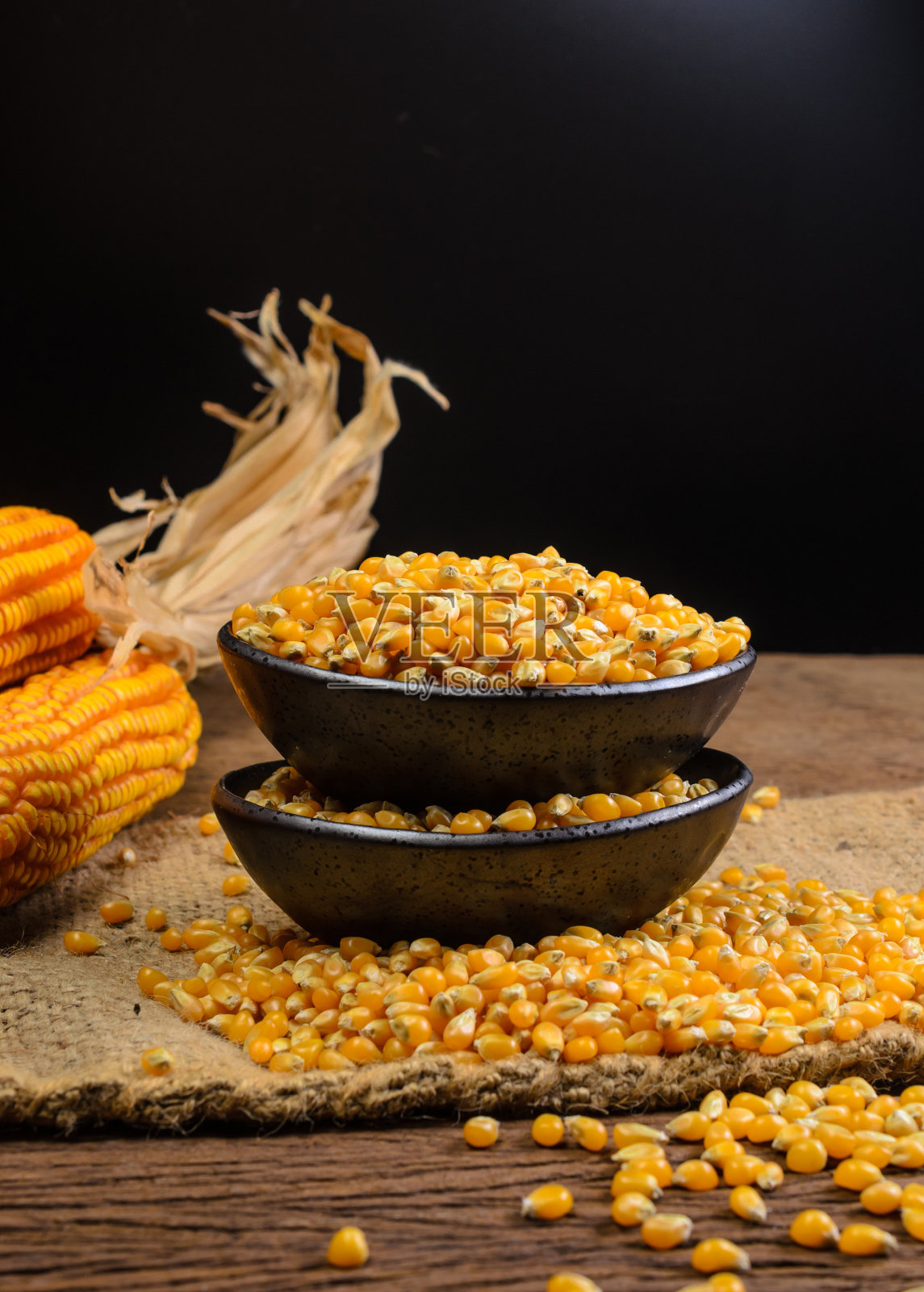 木桌上黑色陶瓷碗里的干玉米照片摄影图片