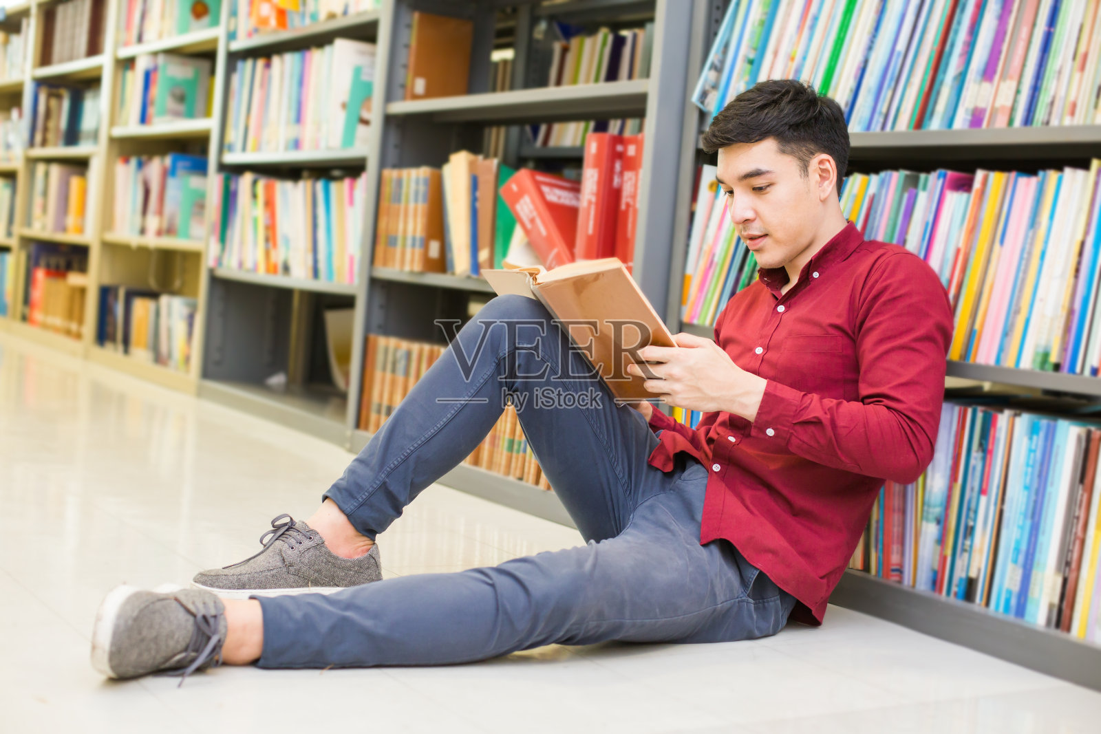 人正在读书。年轻的亚洲人正在现代图书馆里读书。具有教育观念的人。照片摄影图片