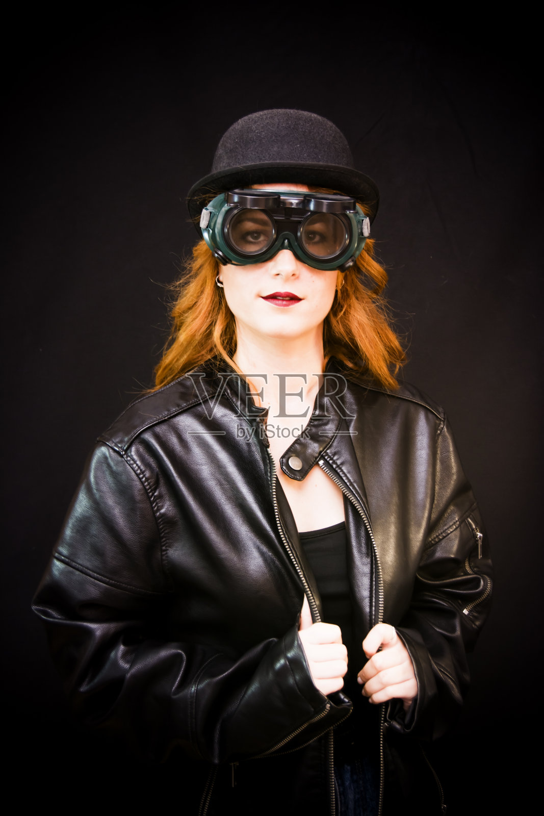 一个美丽的女人的肖像与特殊的眼镜和帽子在黑色的背景照片摄影图片