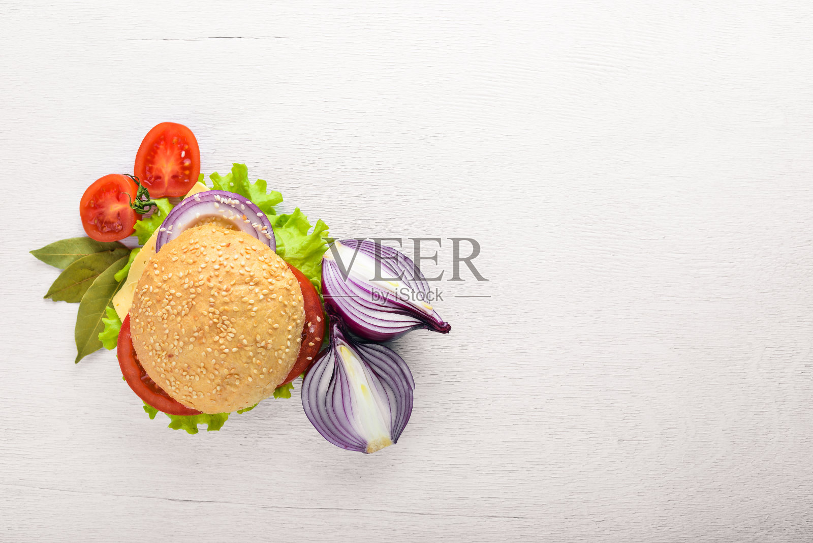 汉堡包配奶酪、肉、西红柿、洋葱和香草。在木制背景。前视图。自由空间。照片摄影图片