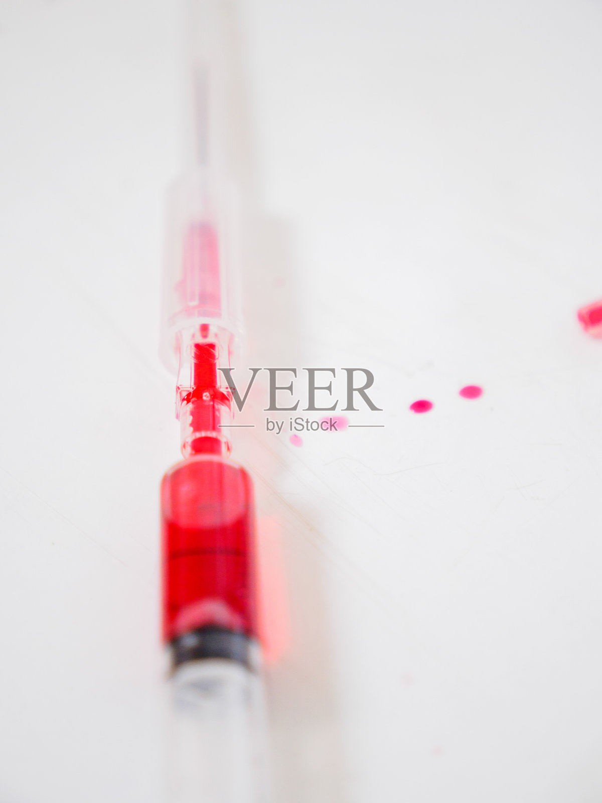 带有红色液体的针头和导管的注射器照片摄影图片