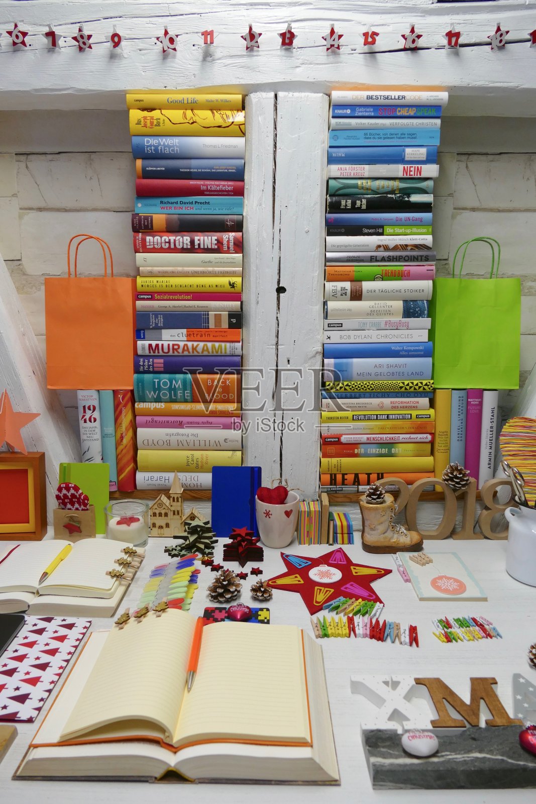 准备圣诞礼物:摆一张满是书籍和剪贴簿的桌子照片摄影图片