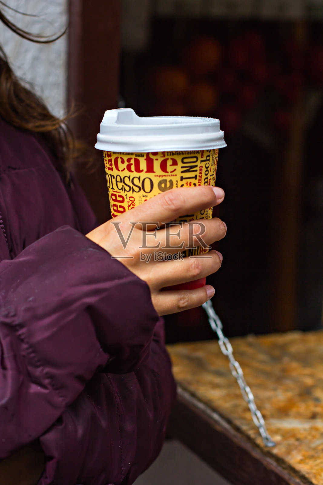 一个女孩手里拿着咖啡纸杯。照片摄影图片