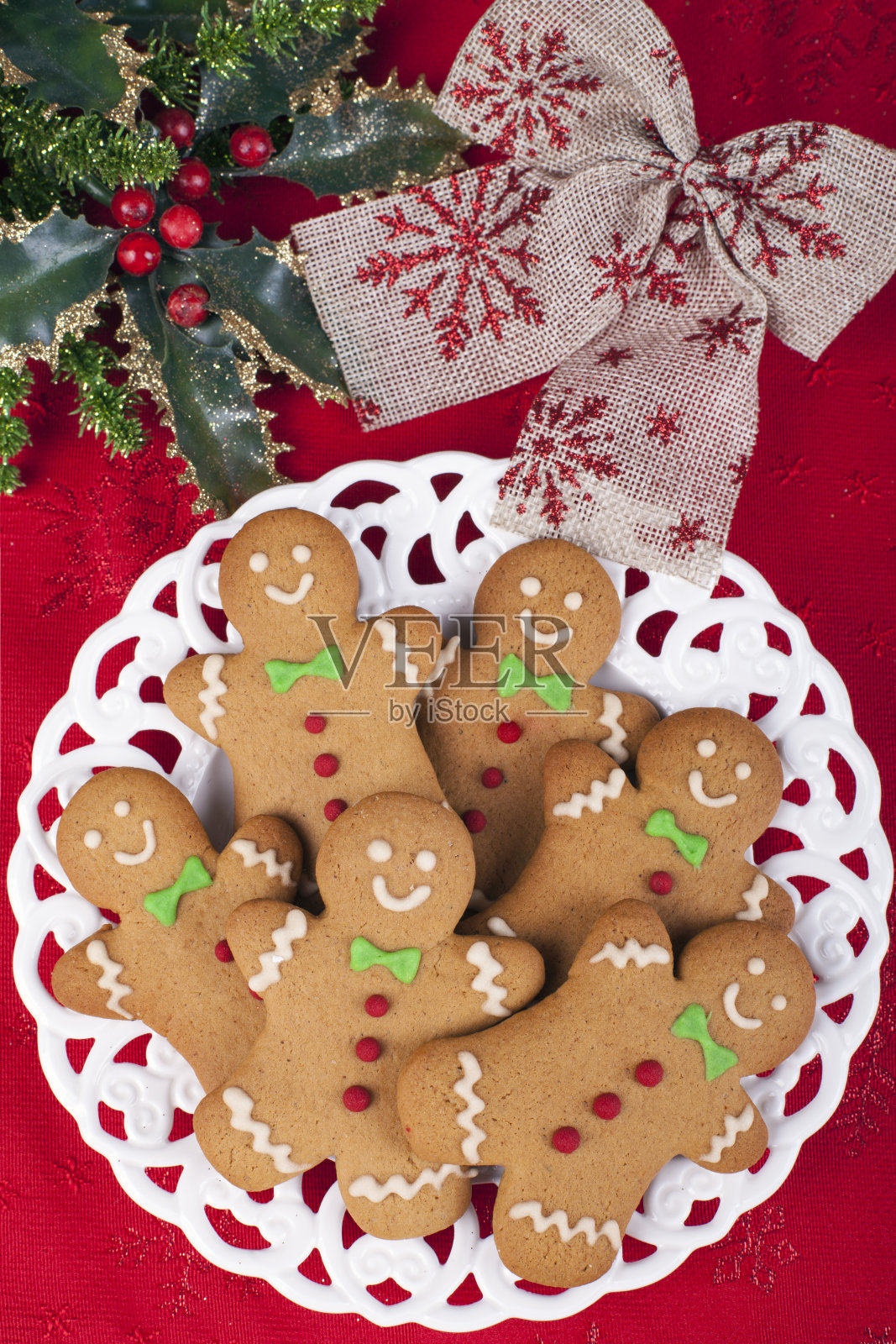 红色桌布上的复古盘子里的圣诞姜饼男人饼干照片摄影图片