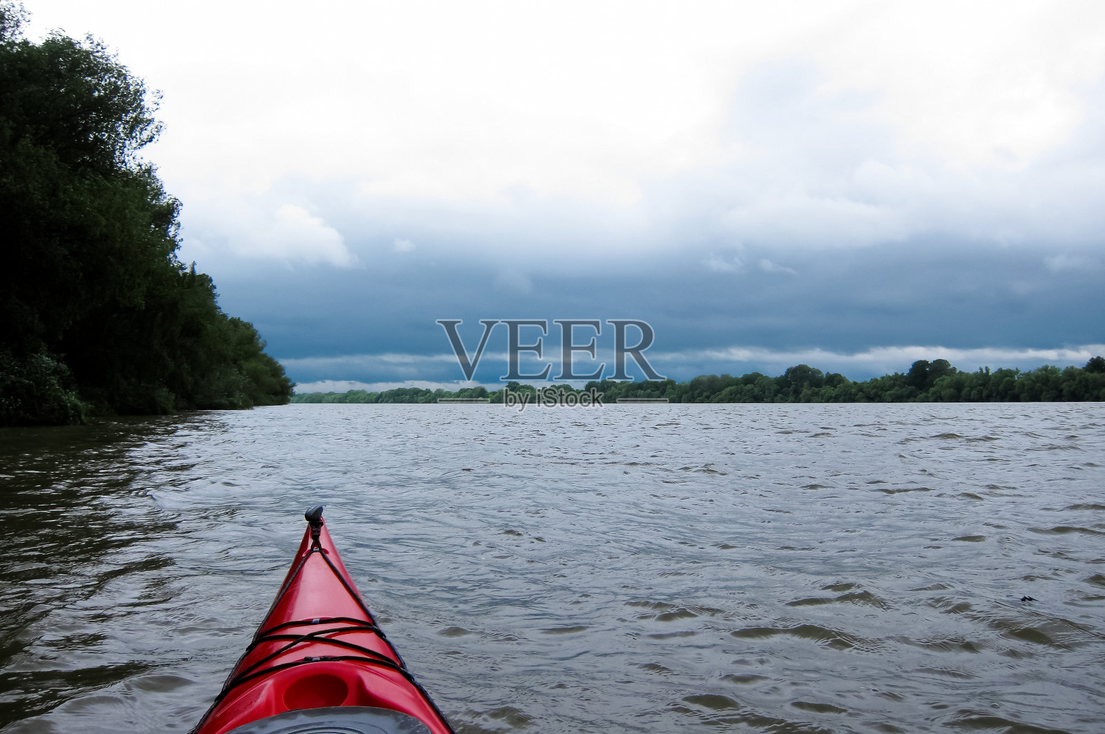 红色皮艇的鼻子在野外自然的背景。皮划艇在野生动物照片摄影图片