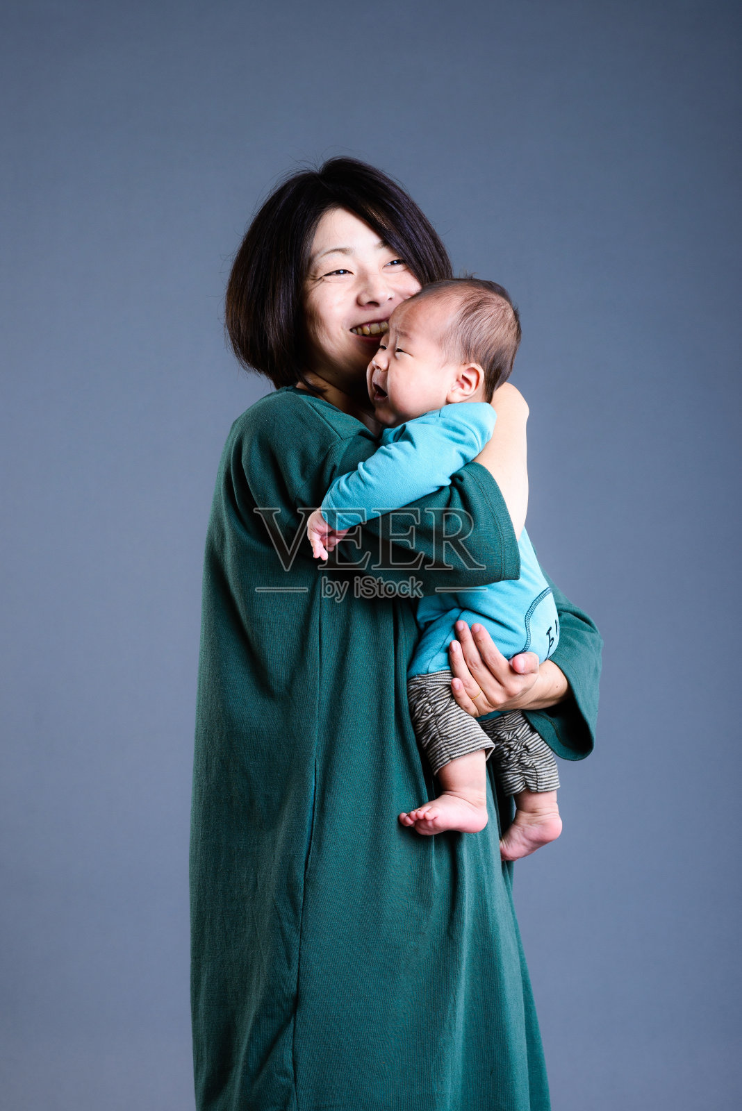 母亲抱着婴儿的工作室肖像照片摄影图片