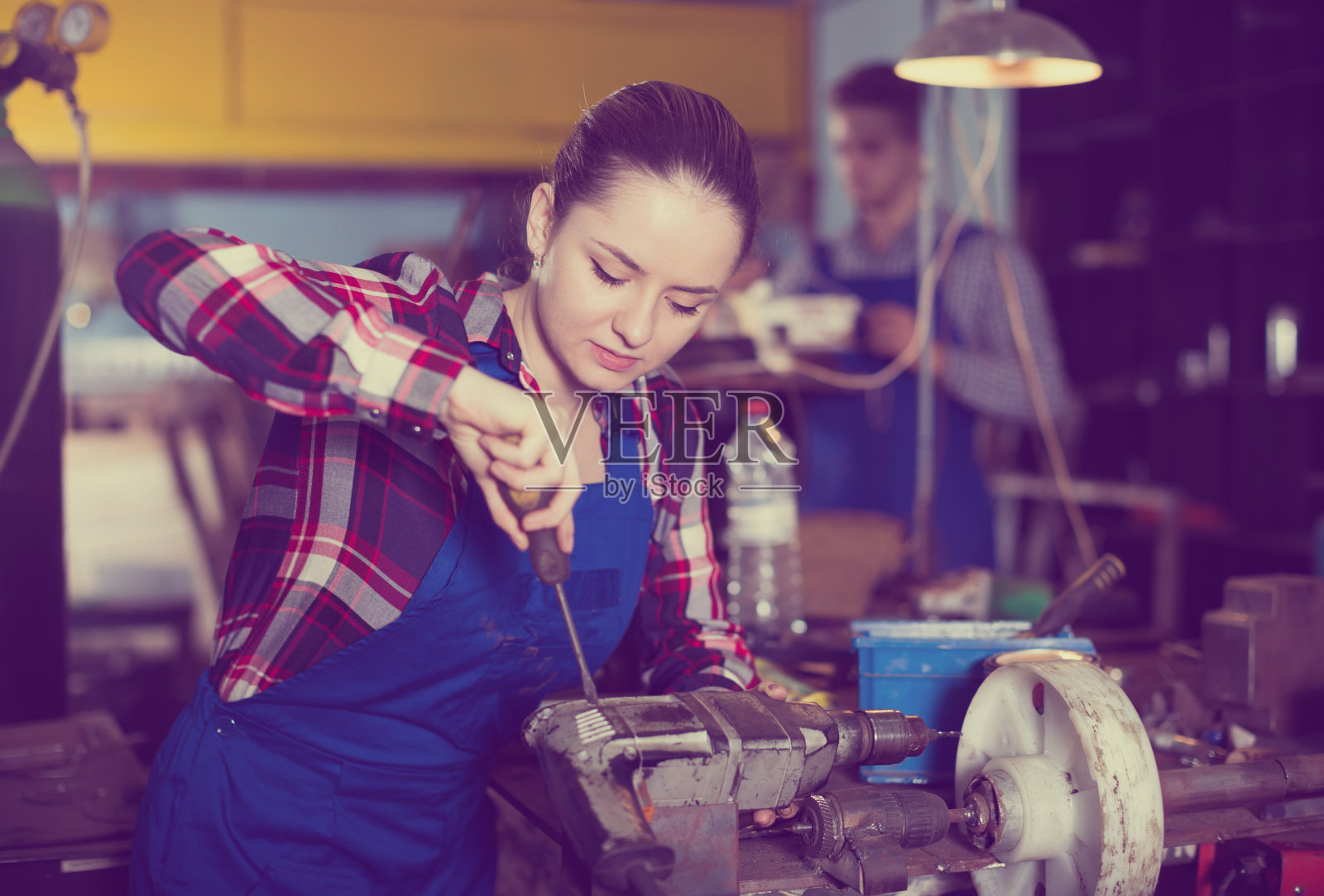 正在修理钻头的女孩照片摄影图片