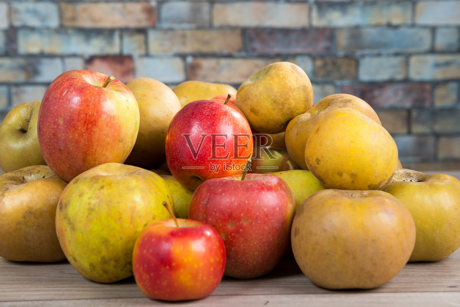 木桌上放着红色和黄色的有机苹果照片摄影图片