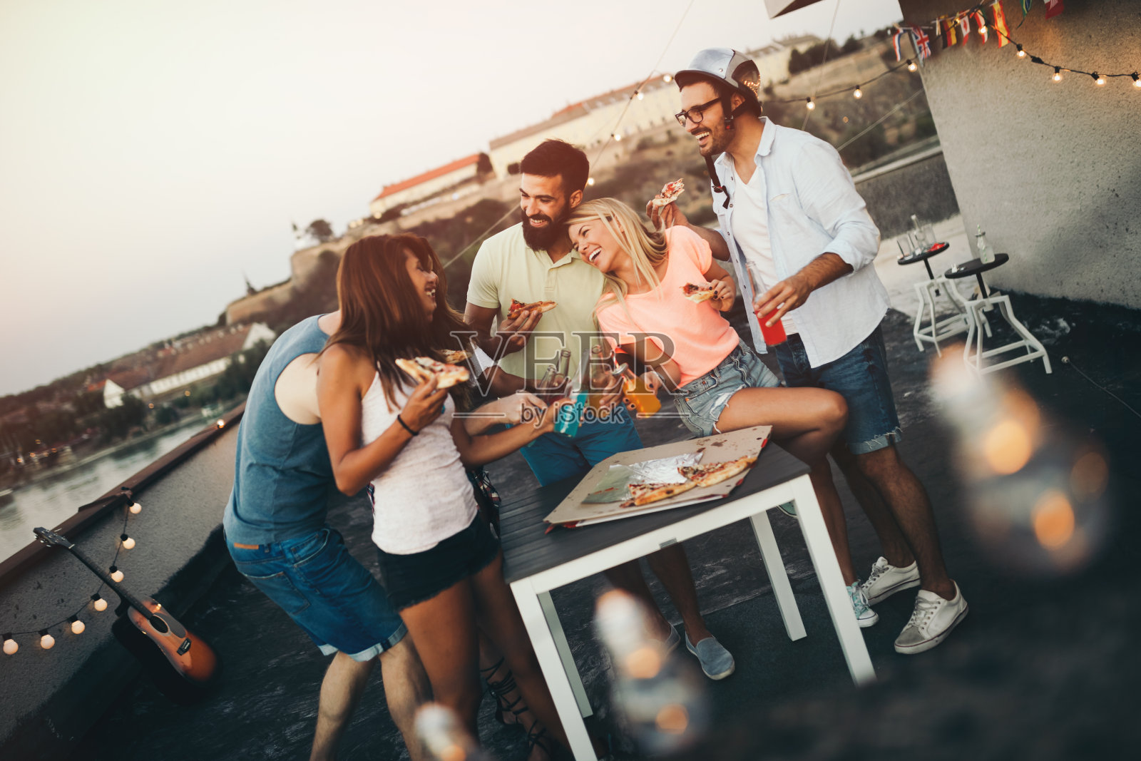 一群快乐的朋友在屋顶上聚会照片摄影图片