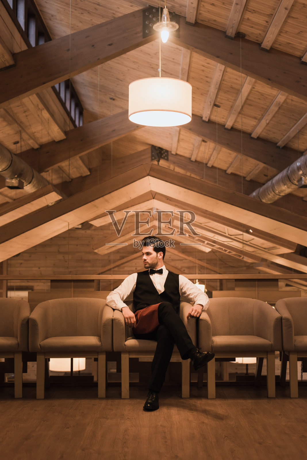 坐在扶手椅里的侍者照片摄影图片