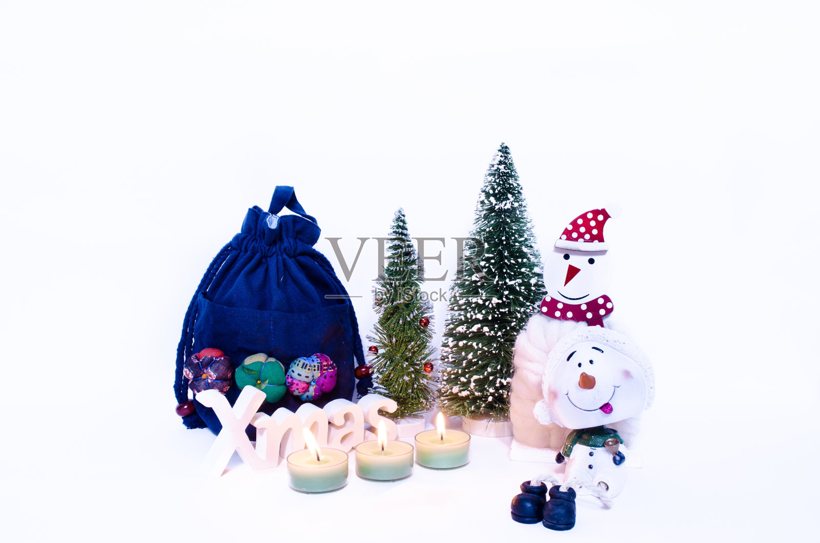 三支蜡烛，两棵圣诞树和一个礼物袋照片摄影图片