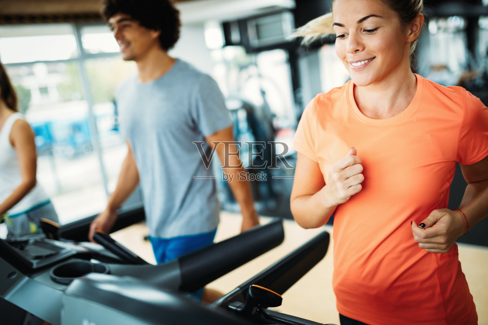年轻迷人的女人在健身房做有氧运动照片摄影图片