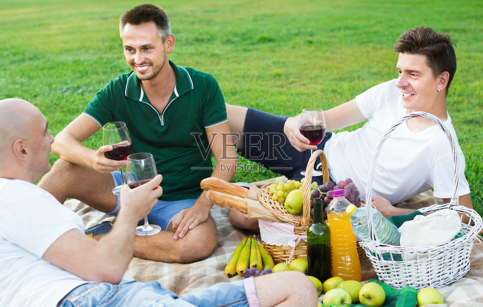 三个快乐的男人朋友正在野餐照片摄影图片