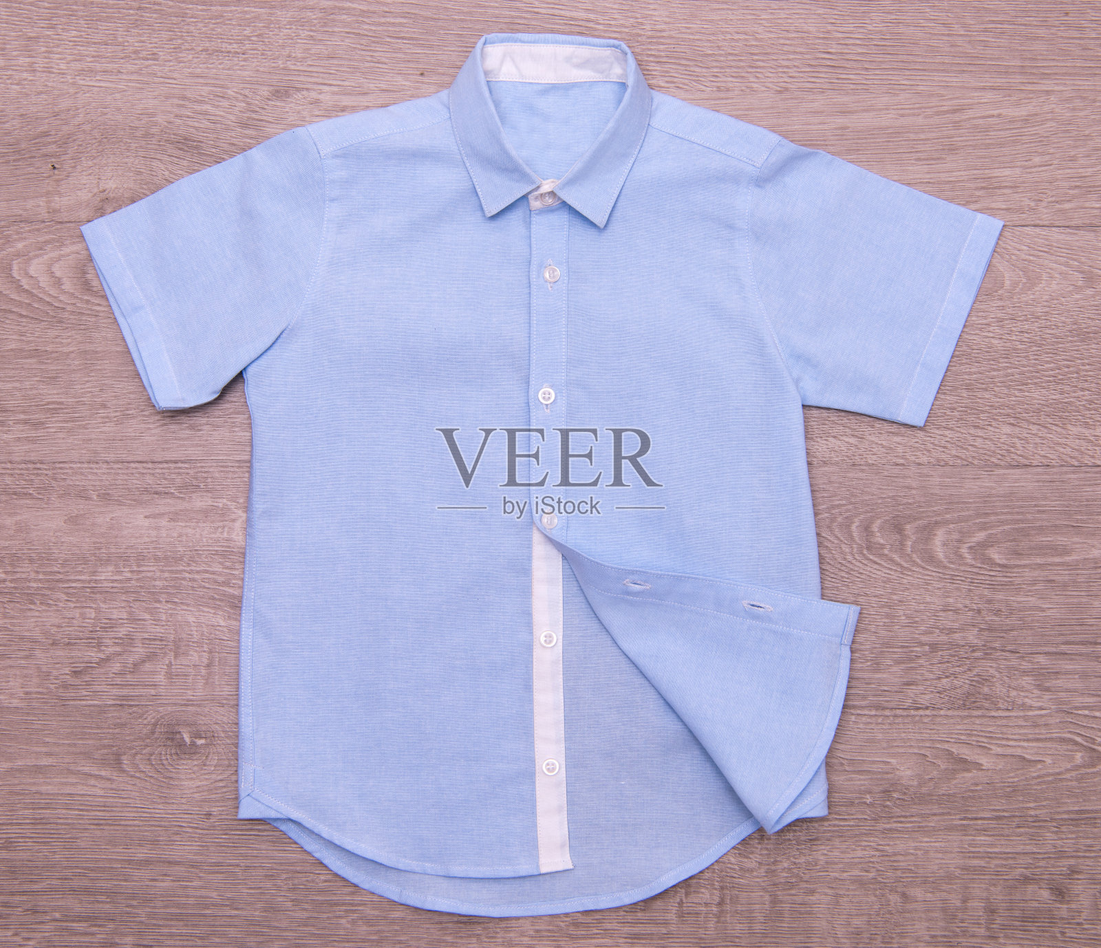 木制背景的蓝色男孩衬衫照片摄影图片