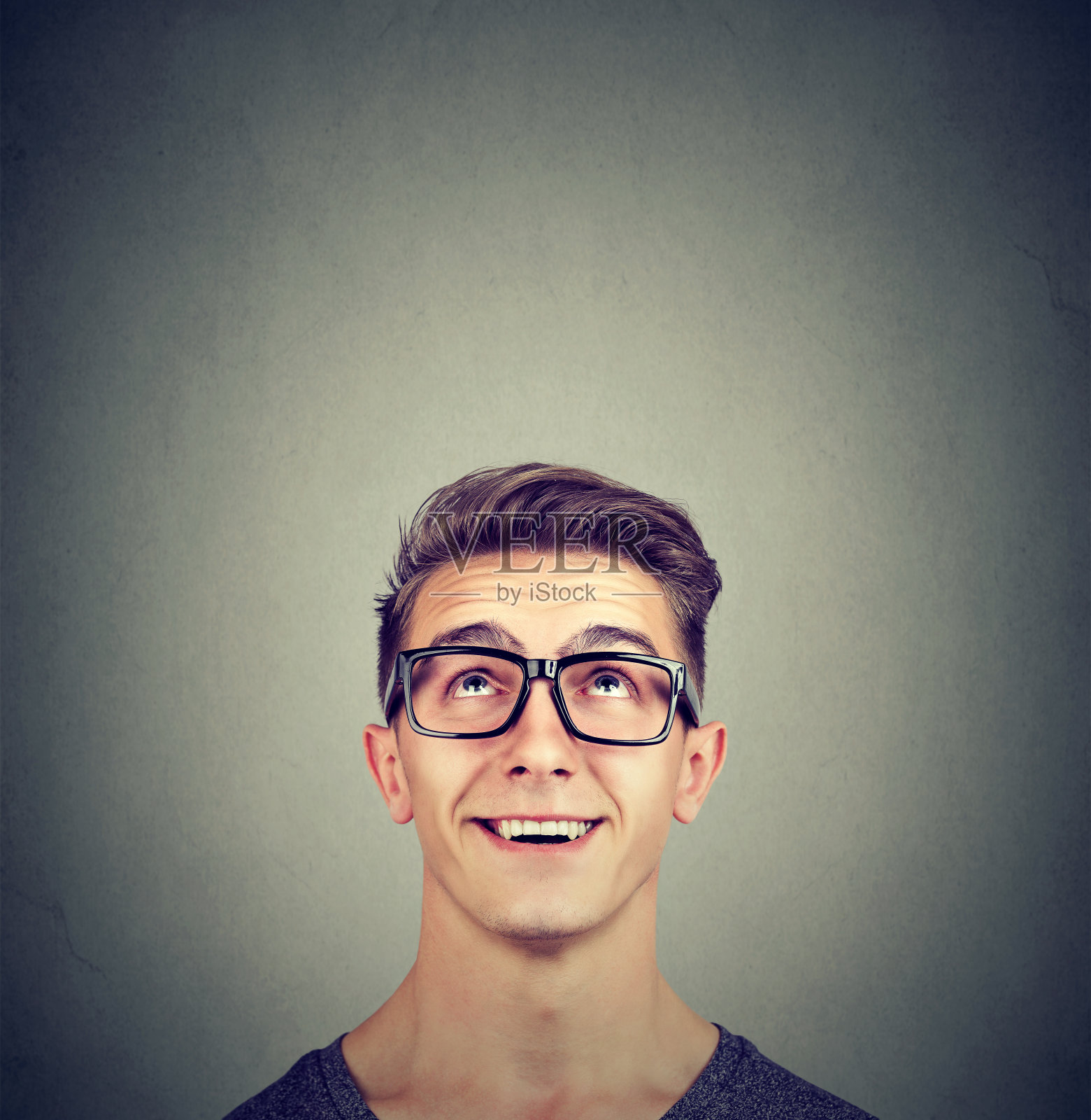 惊讶快乐的男人戴着眼镜抬头看照片摄影图片