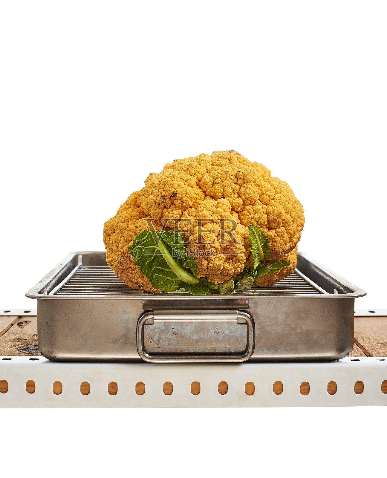 生的黄色花椰菜在金属烤箱托盘。照片摄影图片