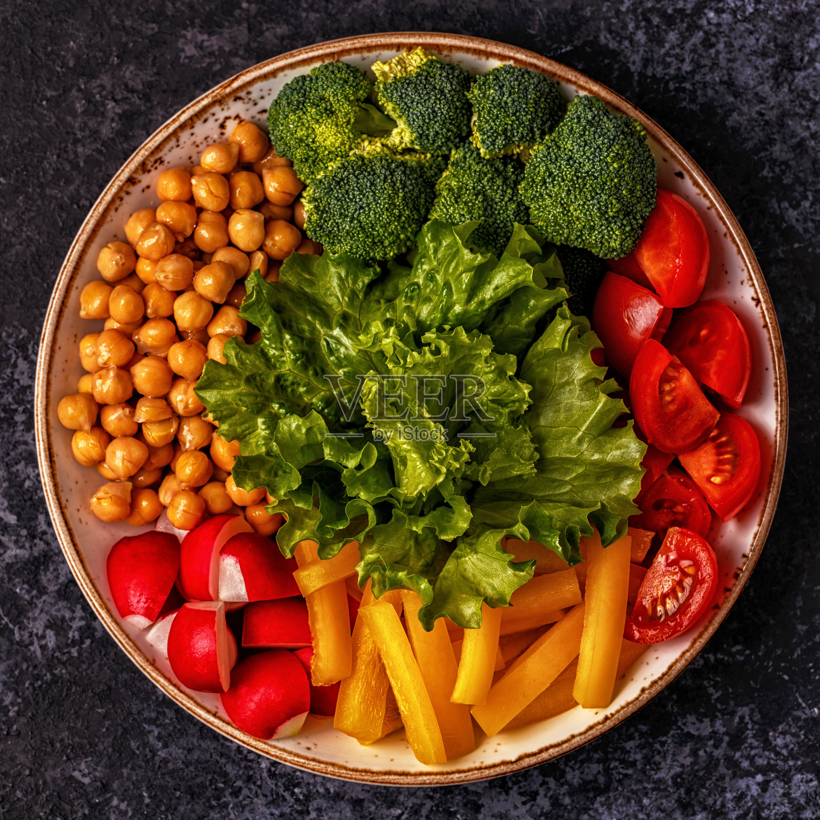 碗蔬菜和鹰嘴豆在黑暗的背景。照片摄影图片