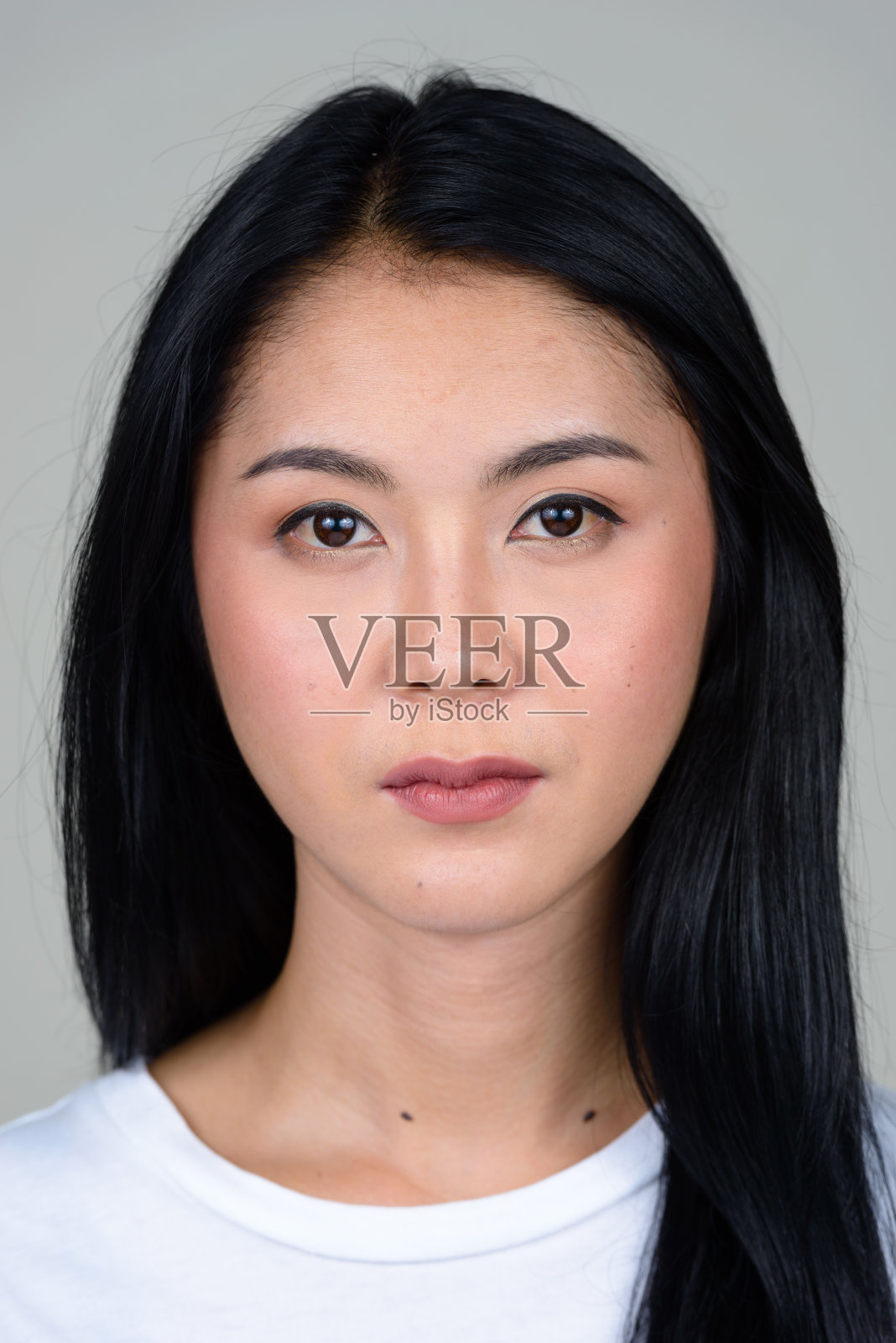 年轻美丽的亚洲女人穿着白色衬衫对抗白色背景照片摄影图片