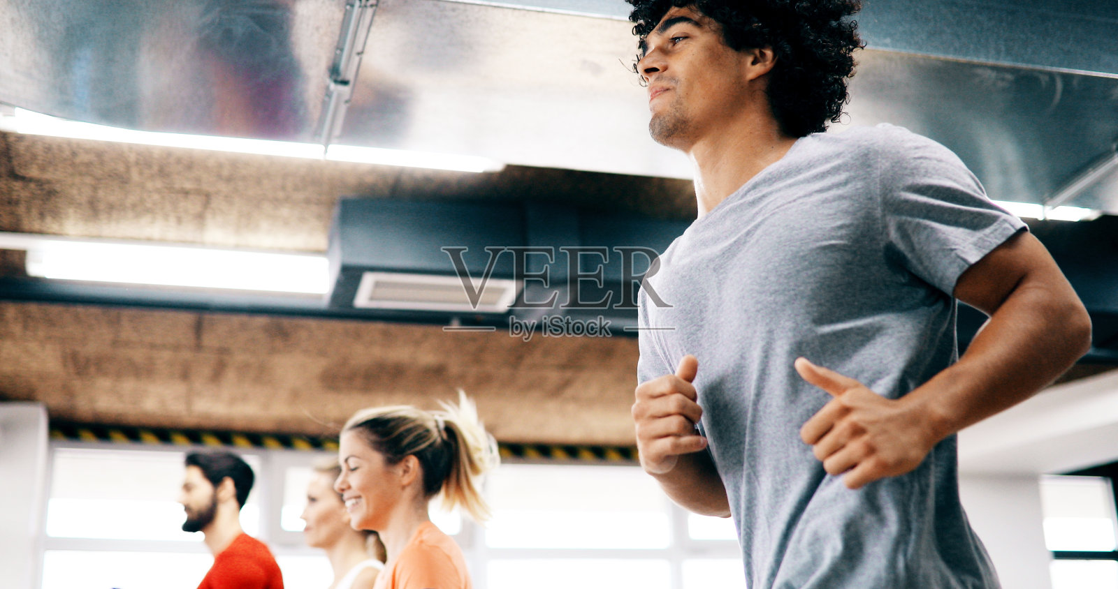 年轻迷人的女人在健身房做有氧运动照片摄影图片