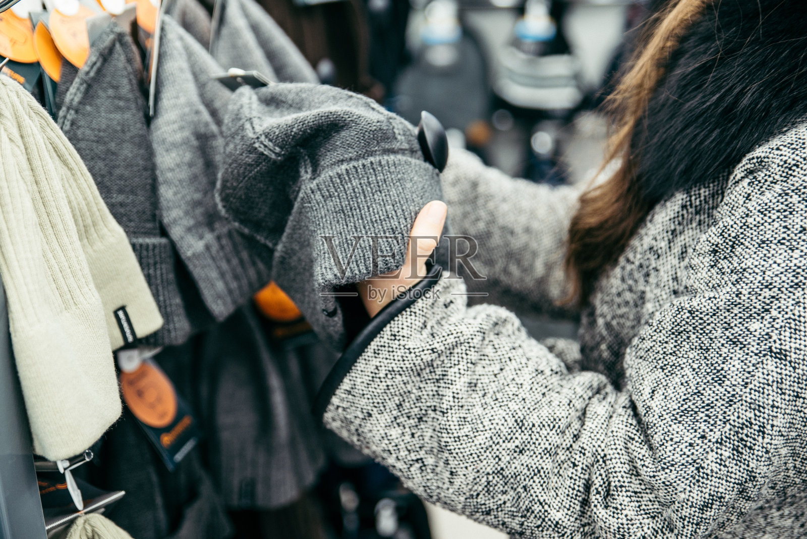 在商店里看帽子的女人照片摄影图片