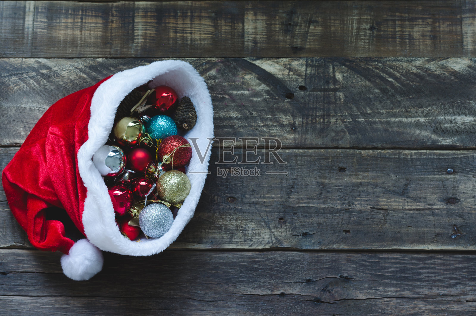 圣诞老人帽子与圣诞装饰的木制背景照片摄影图片