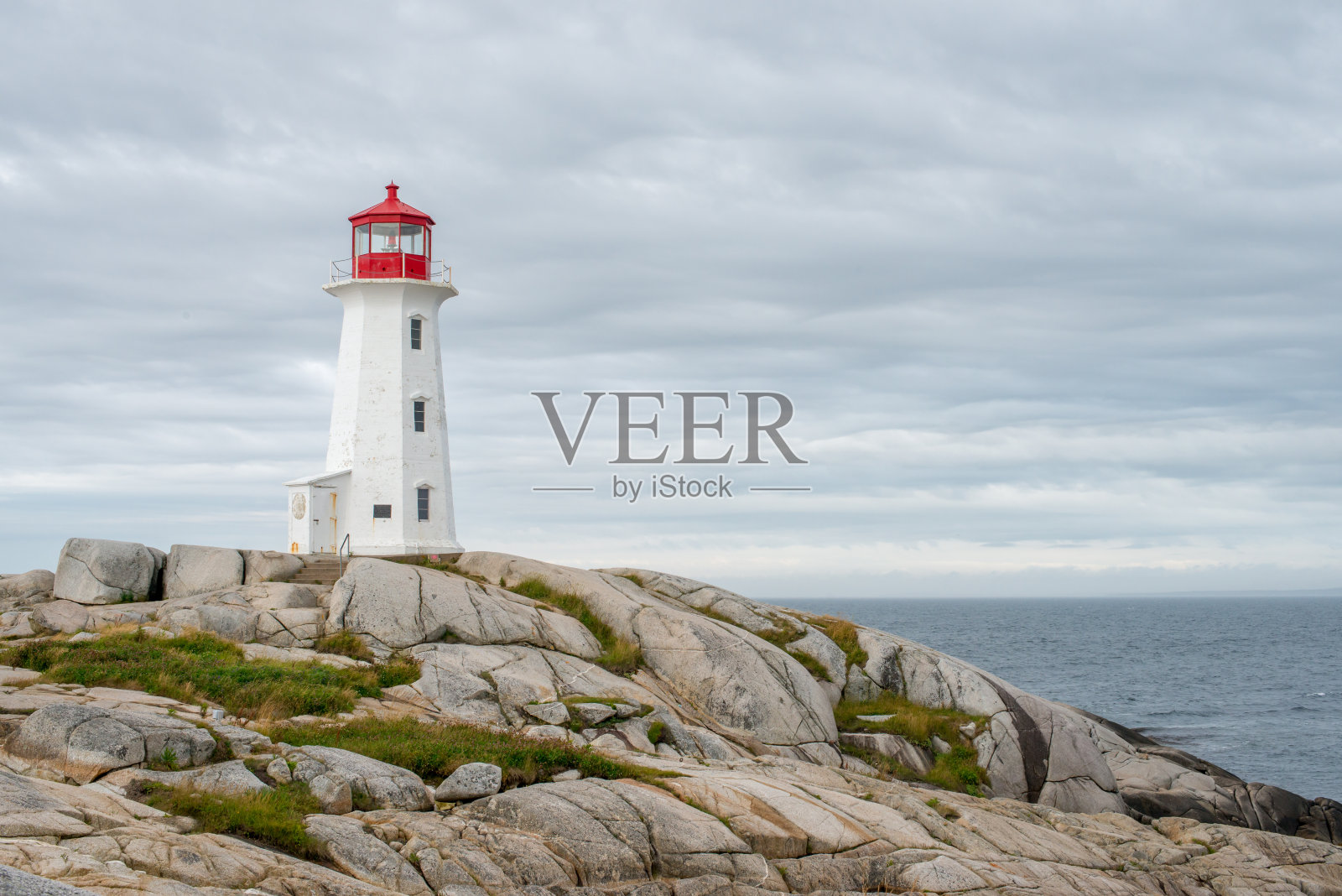 多云天空下的佩吉湾灯塔照片摄影图片