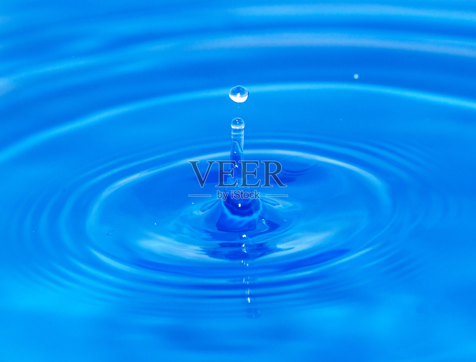 抽象的背景。水滴落在蓝色的水中照片摄影图片