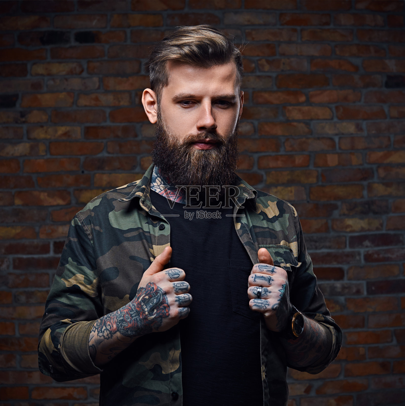 穿着军服的有纹身的大胡子男人。照片摄影图片