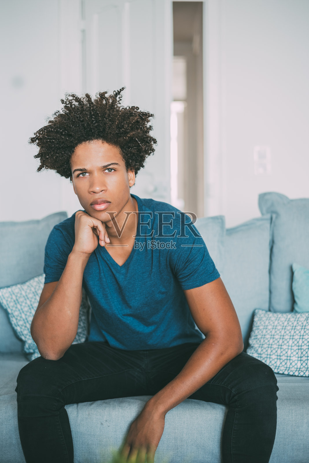 一个年轻的混血儿坐在沙发上的肖像照片摄影图片