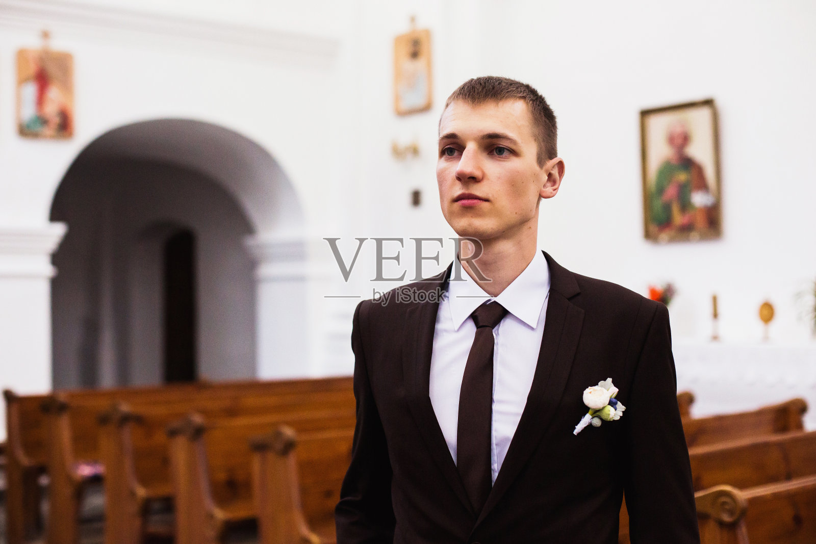 教堂里穿着棕色西装的新郎。创意婚纱摄影。照片摄影图片