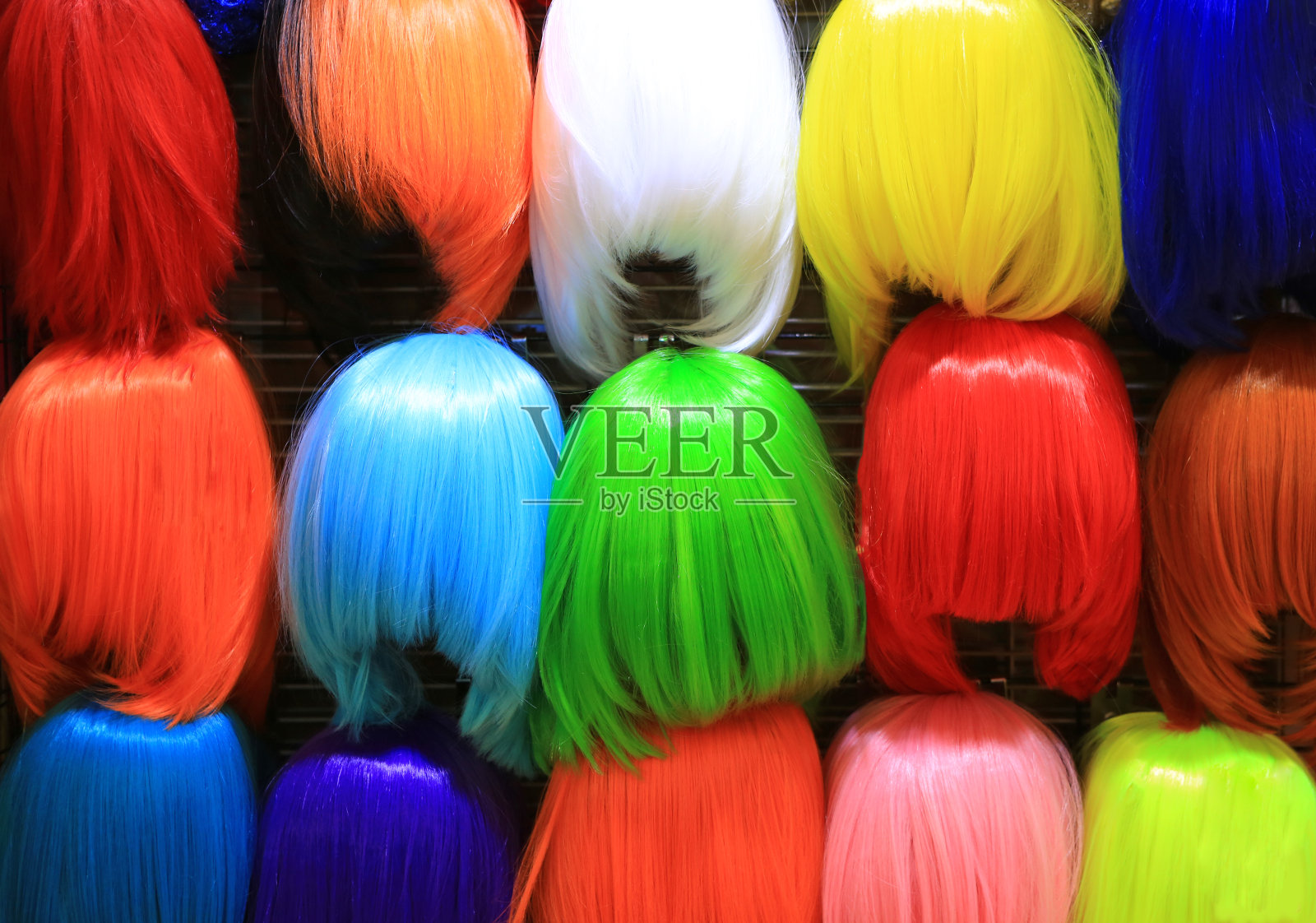 五颜六色的假发配件。市场销售。女人戴不同的假发。照片摄影图片