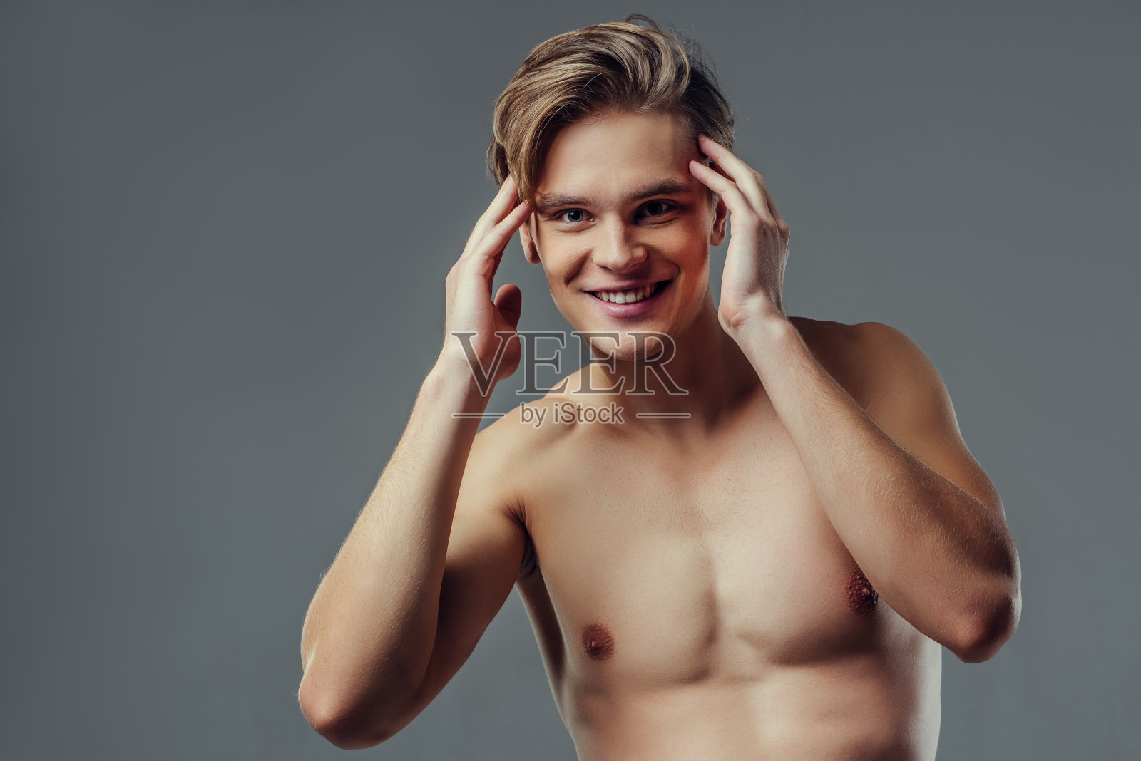 灰色背景上的英俊男子。照片摄影图片