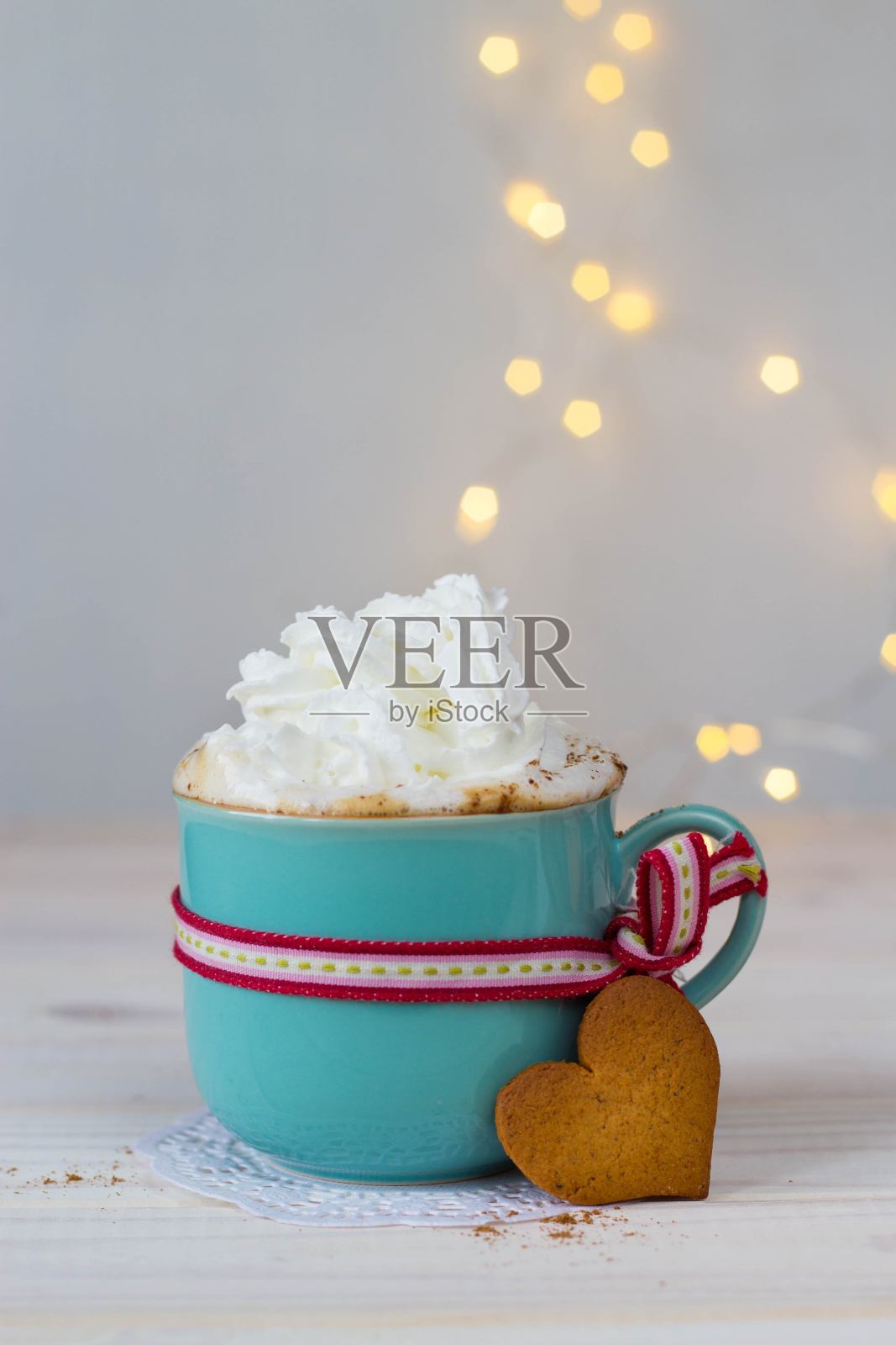 一杯热巧克力，奶油，心型姜饼，以散景为背景照片摄影图片