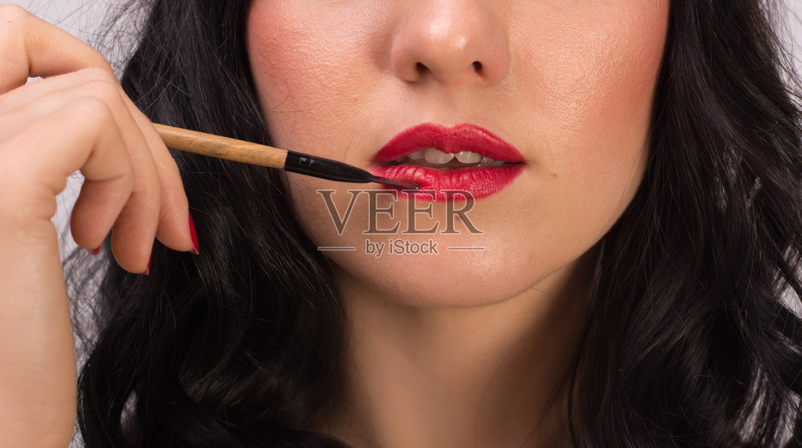 女孩的嘴唇，这是她用化妆刷画的，特写。照片摄影图片