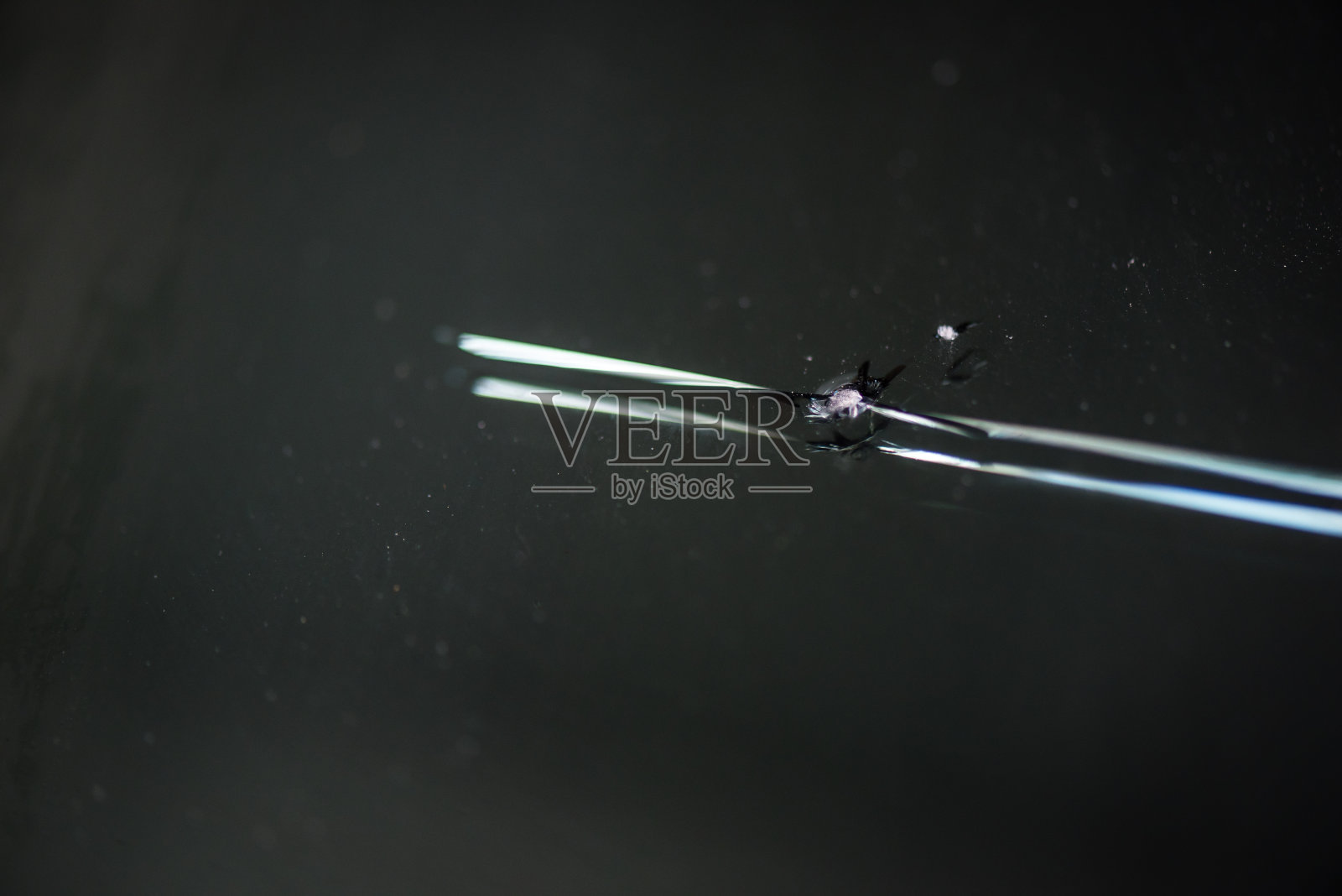 小挡风玻璃因石头或子弹而破裂。运输和事故概念。汽车镜和玻璃主题。有选择性的重点照片摄影图片