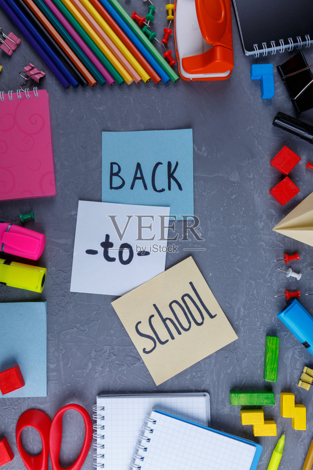 树叶上有回校的题词，四周摆放着各种文具。从以上观点。照片摄影图片