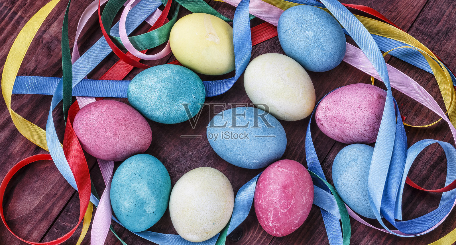 复活节彩蛋篮配上五彩缤纷的彩带，春天的花朵选择性聚焦。顶视图,水平。照片摄影图片