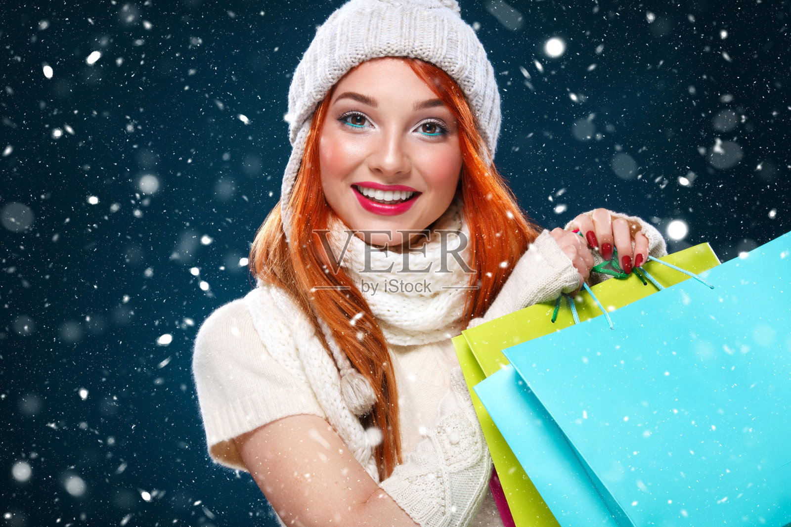 圣诞节和新年假期。购物的女人拿着彩色的包，在冬天的背景与雪在黑色星期五。有拷贝空间的销售海报。照片摄影图片