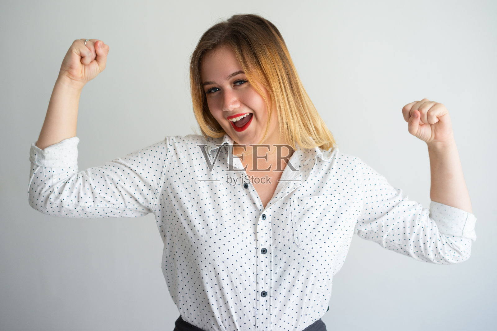 兴奋有力的年轻女子显示肌肉照片摄影图片