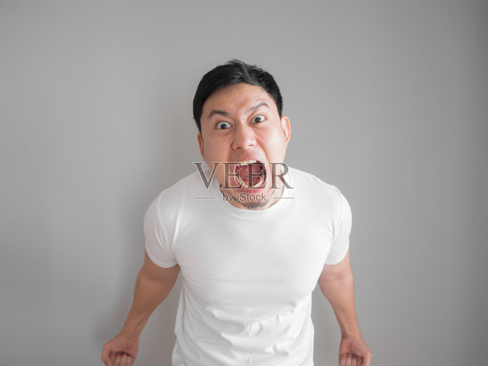 非常生气的攻击性男子肖像白色t恤。照片摄影图片