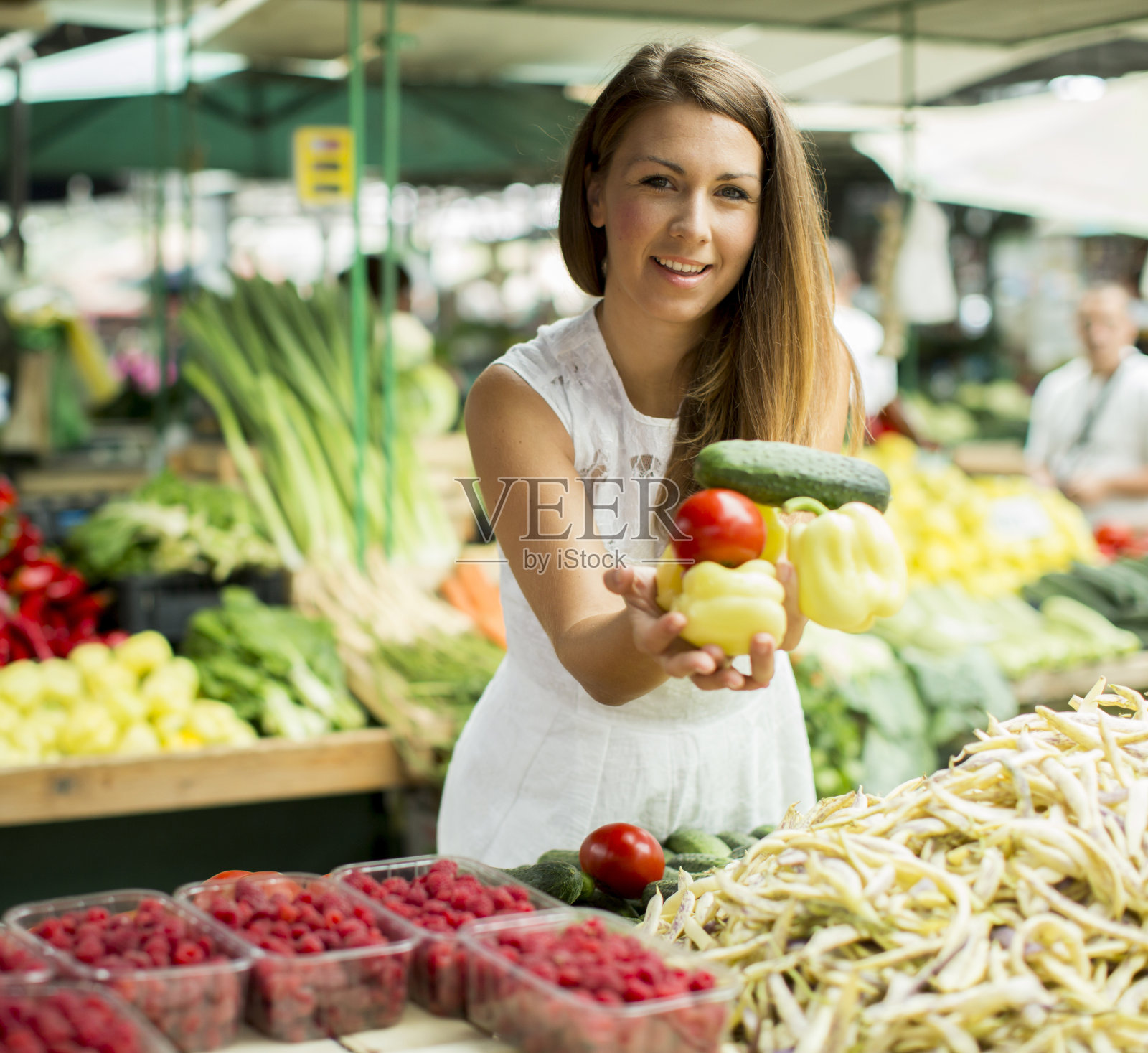 年轻女子在市场上采摘新鲜蔬菜照片摄影图片