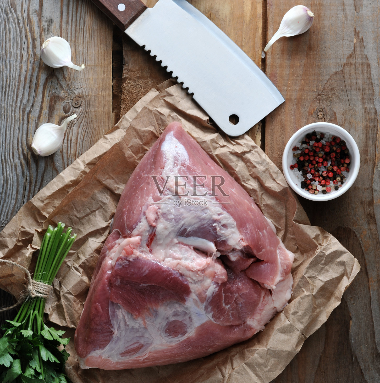 生猪肉块，大火腿和一把大砍刀照片摄影图片