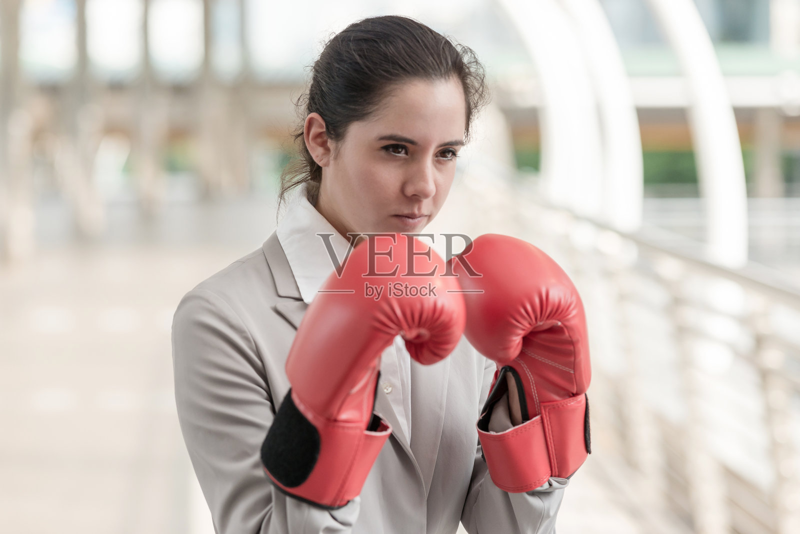 戴拳击手套的女商人。照片摄影图片