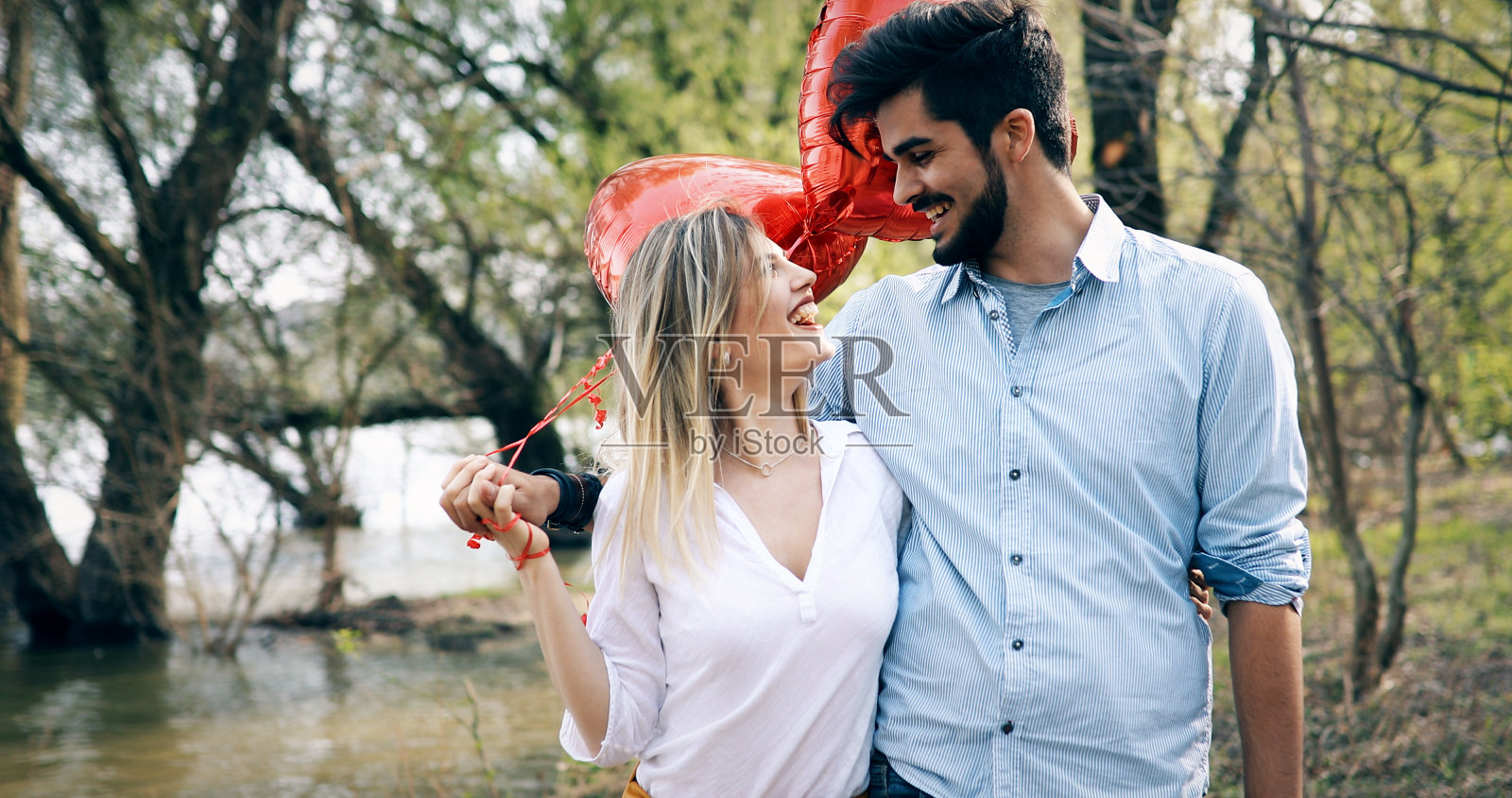 一个男人站着，背后拿着一个白色的惊喜礼盒照片摄影图片