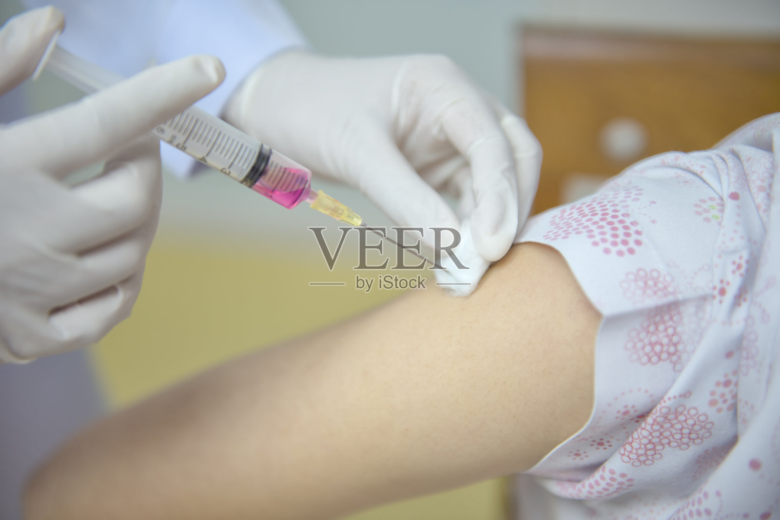 软焦点护士用注射器给病人接种疫苗。医生在医院为妇女接种疫苗。治疗时使用无菌注射上臂。注射照片摄影图片